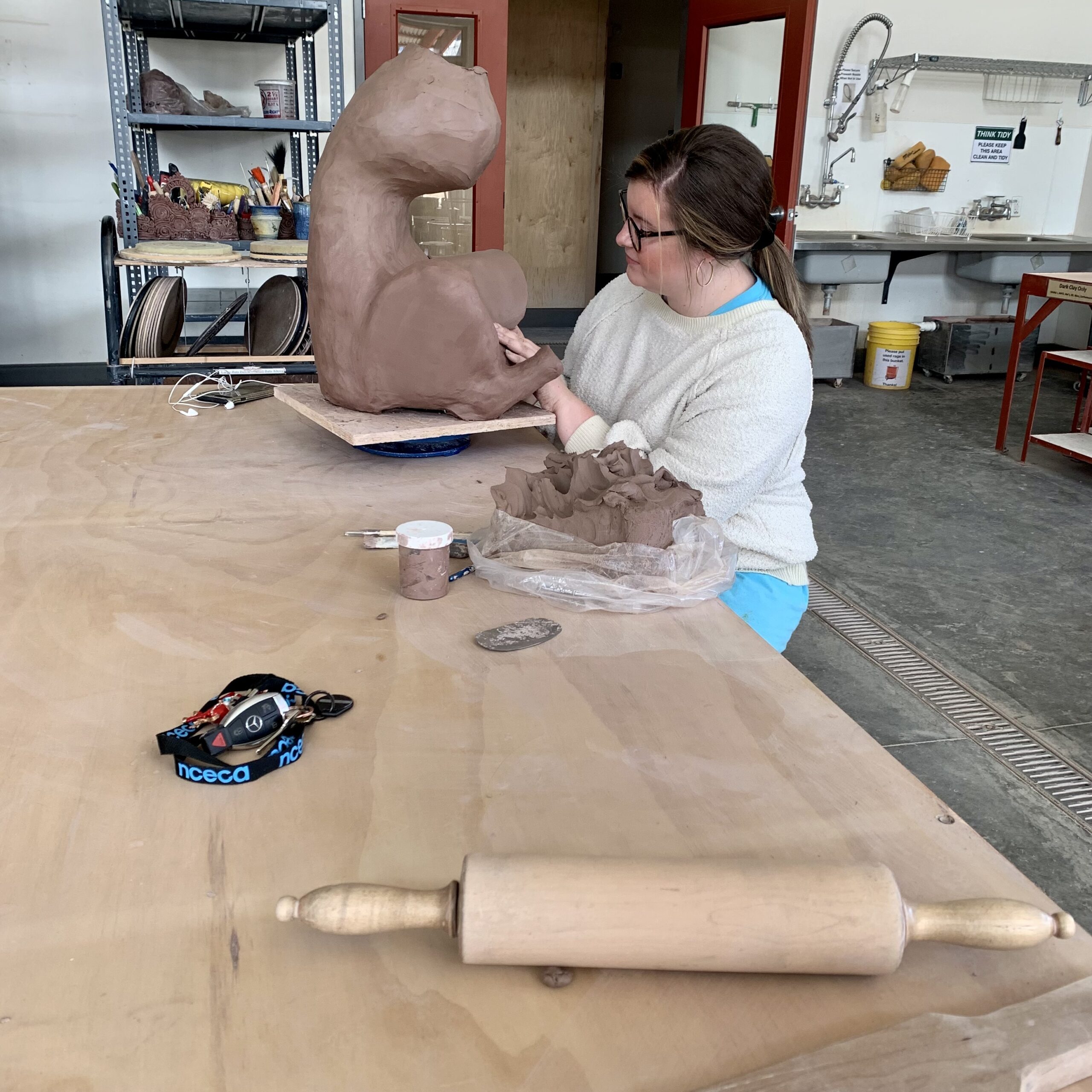 Person sculpting an animal form
