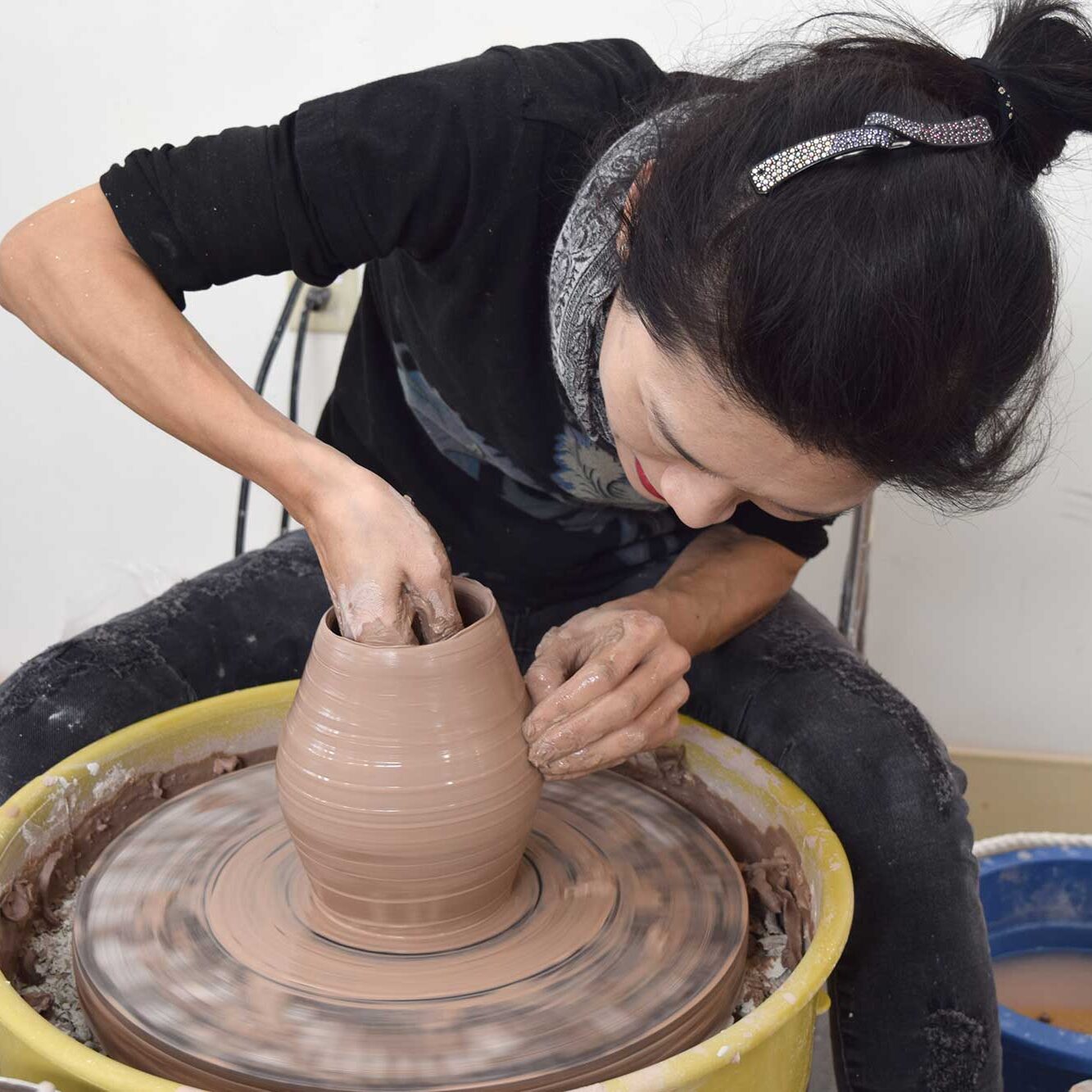 Personal forming a vase on a clay wheel