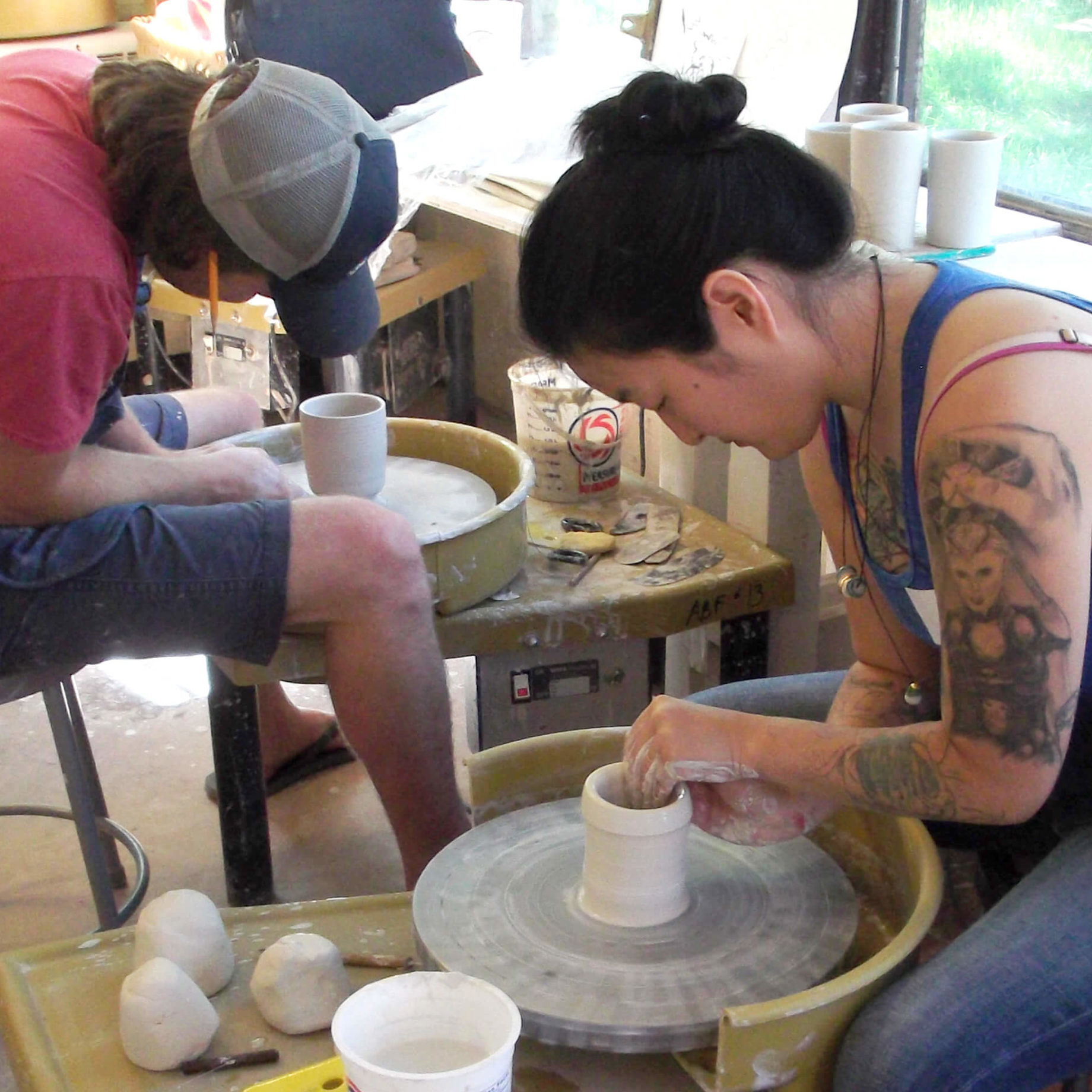 People working with clay on wheels during Summer Programming
