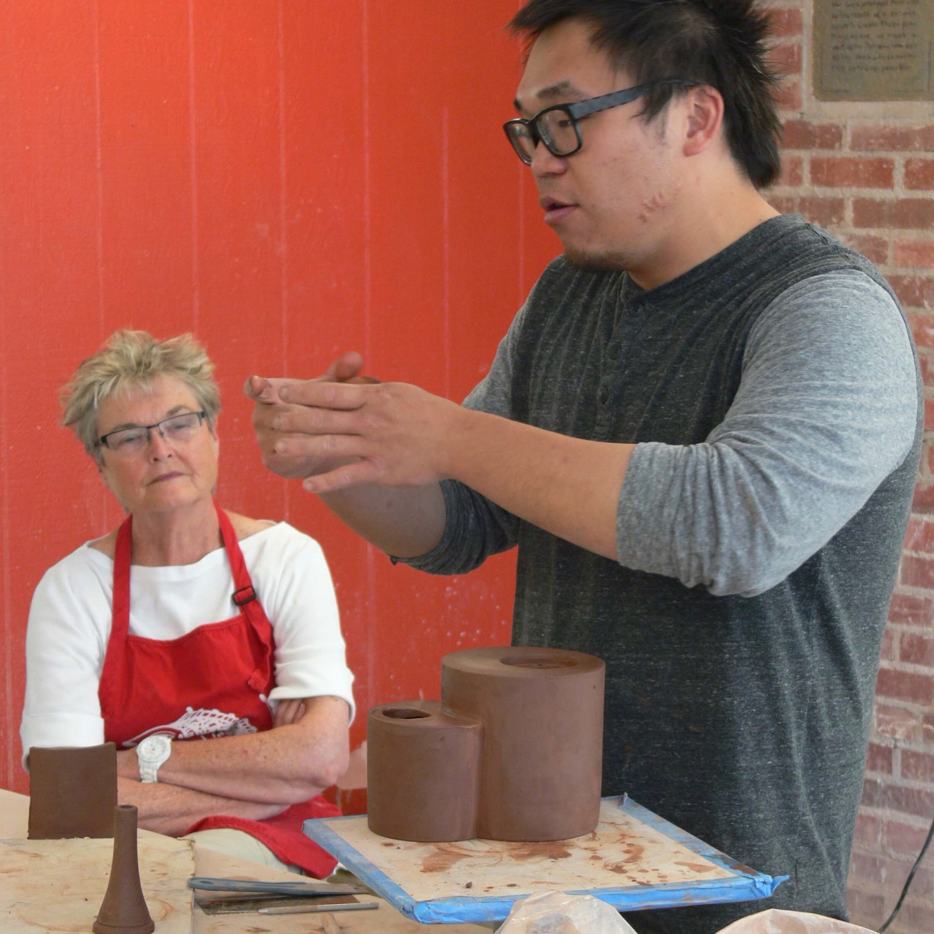 Artist describing clay work to students